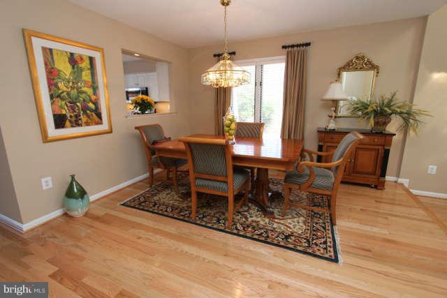 1330 Wedgewood Manor Way Reston, VA 20194 - Photo 7 of 30 a dining room with furniture a rug a potted plant and wooden floor