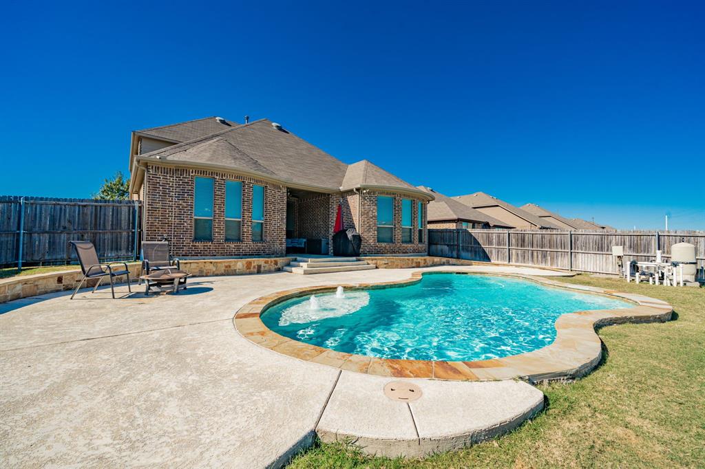 View of swimming pool with a patio and a fenced backyard
