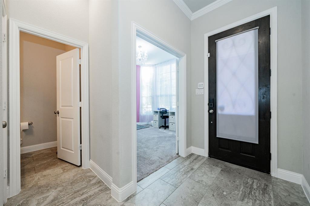 593 Spruce Trail Forney, TX 75126 - Photo 16 of 40 Foyer entrance featuring ornamental molding and a chandelier