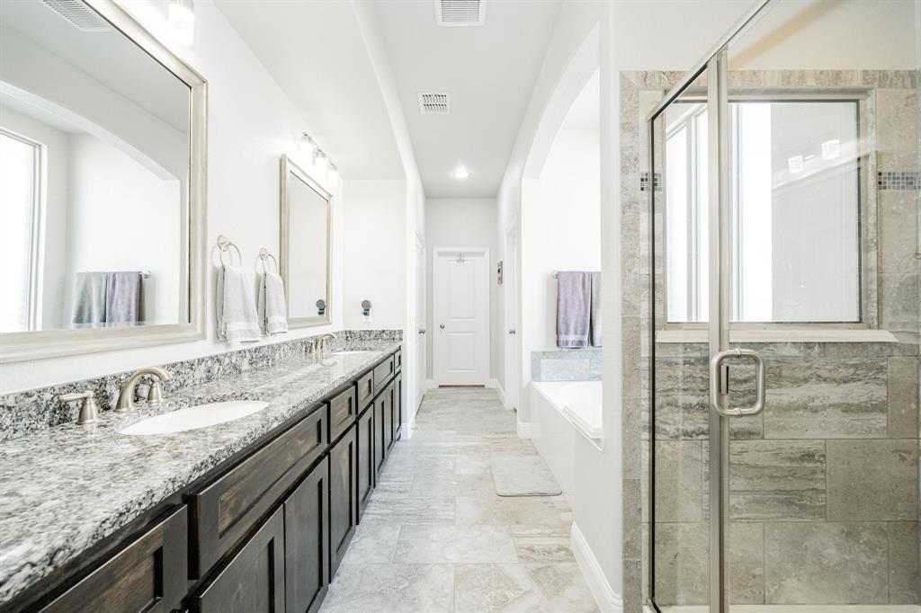 593 Spruce Trail Forney, TX 75126 - Photo 22 of 40 Bathroom featuring a garden tub, double vanity, and a stall shower