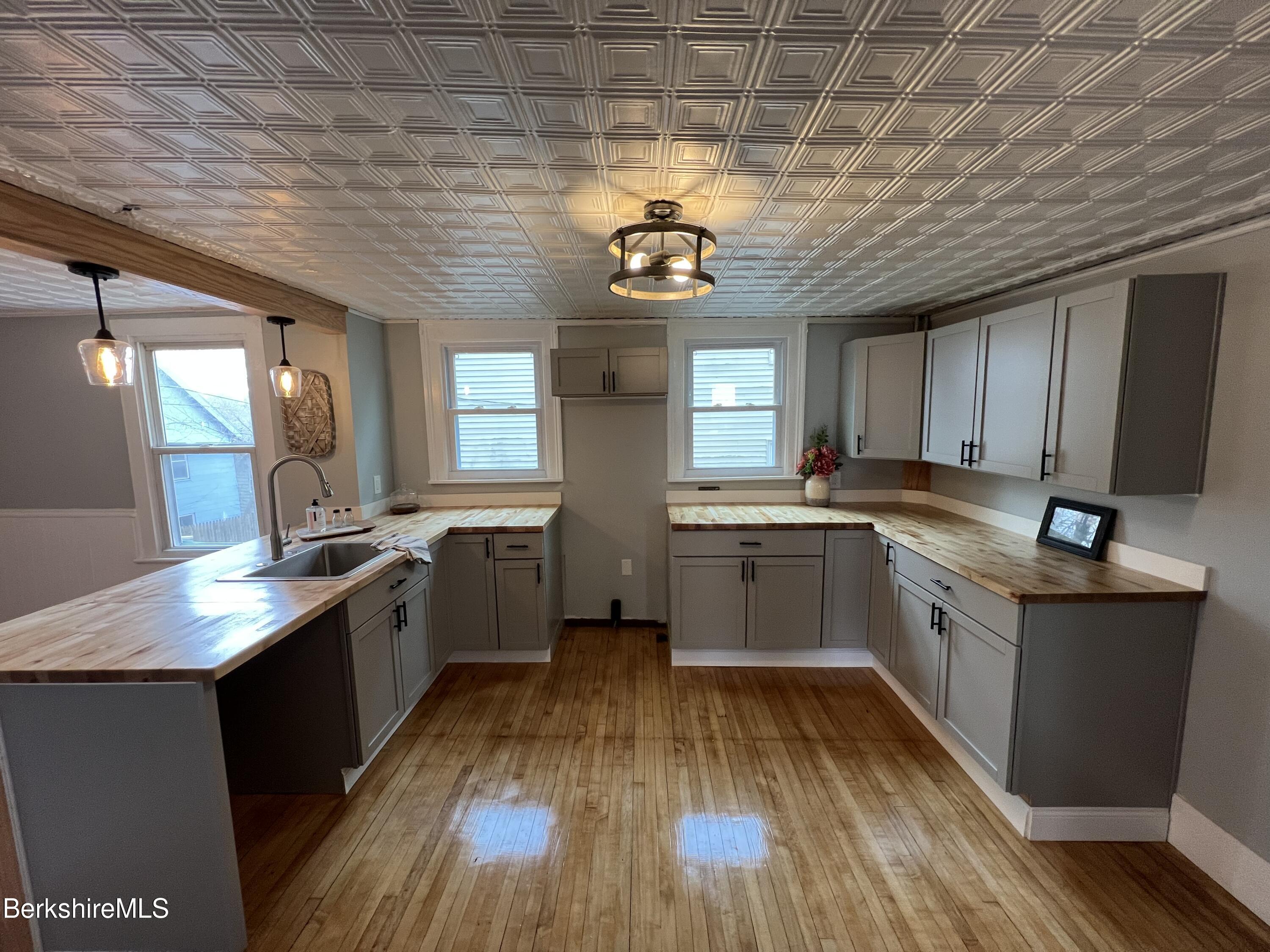 71 Howard Street Pittsfield, MA 01201 - Photo 11 of 42 a kitchen with a sink a counter top space stainless steel appliances and cabinets