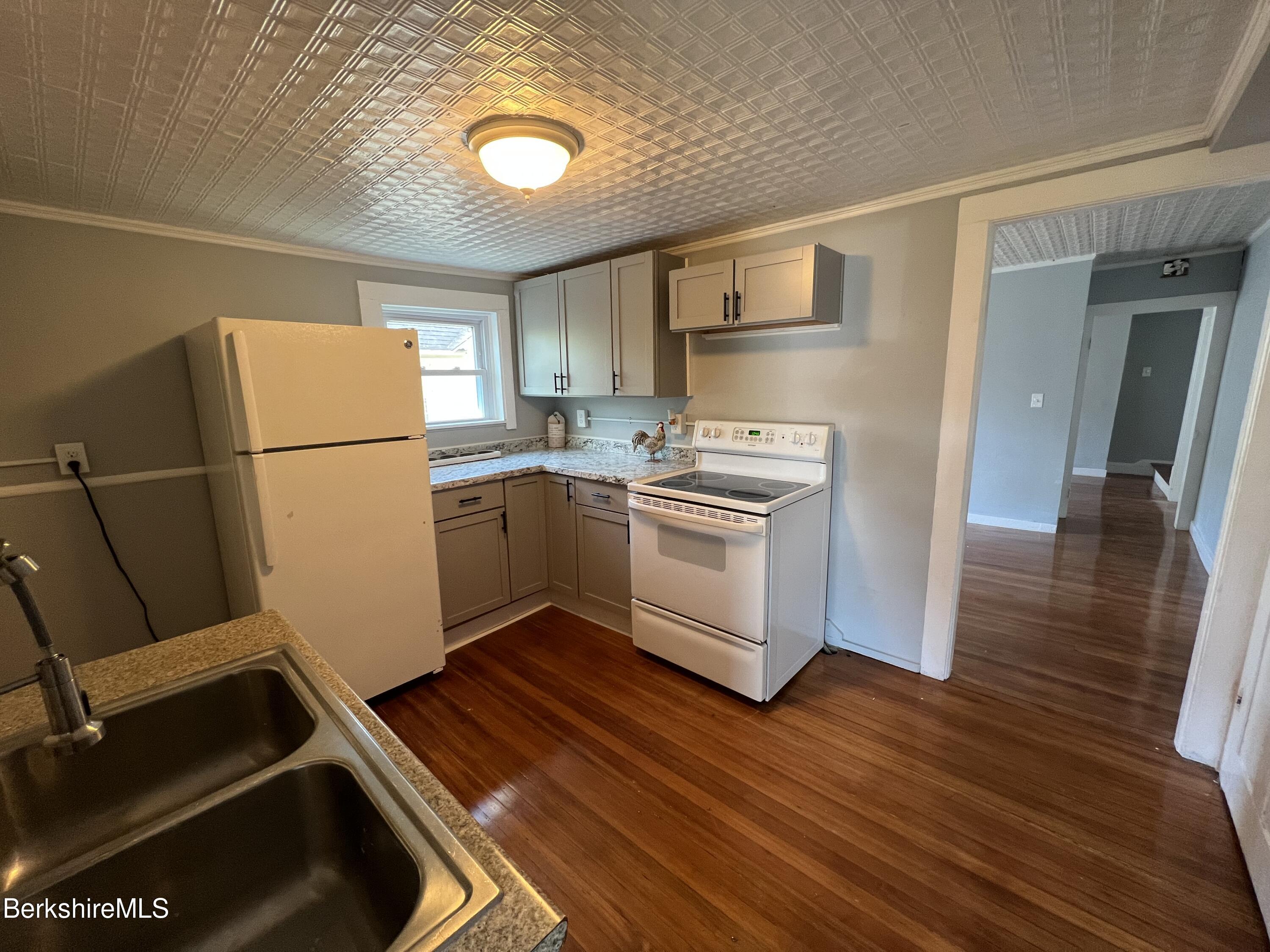 71 Howard Street Pittsfield, MA 01201 - Photo 24 of 42 a kitchen with a refrigerator a stove top oven a sink and dishwasher