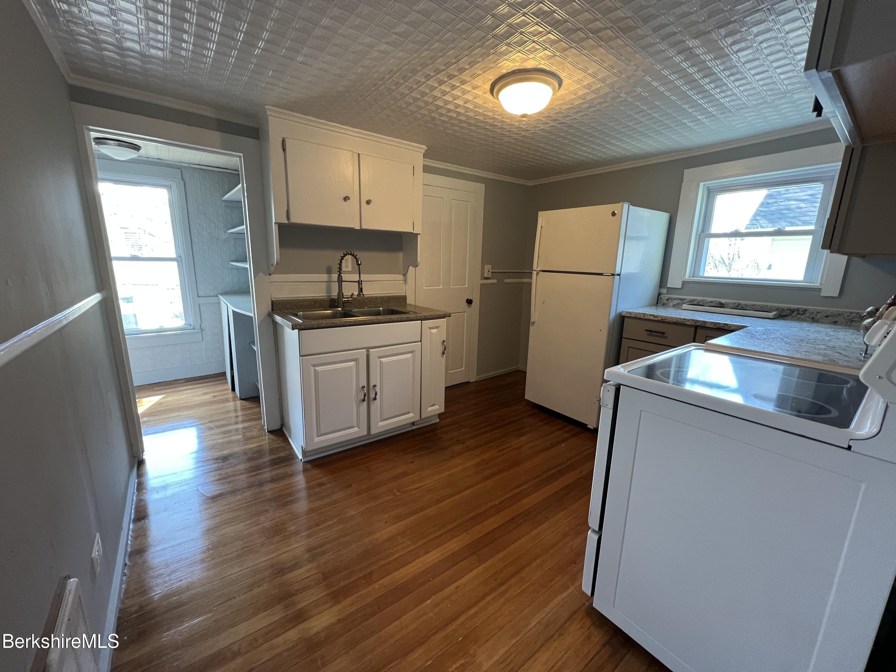 71 Howard Street Pittsfield, MA 01201 - Photo 25 of 42 a kitchen with granite countertop a sink wooden floor and stainless steel appliances
