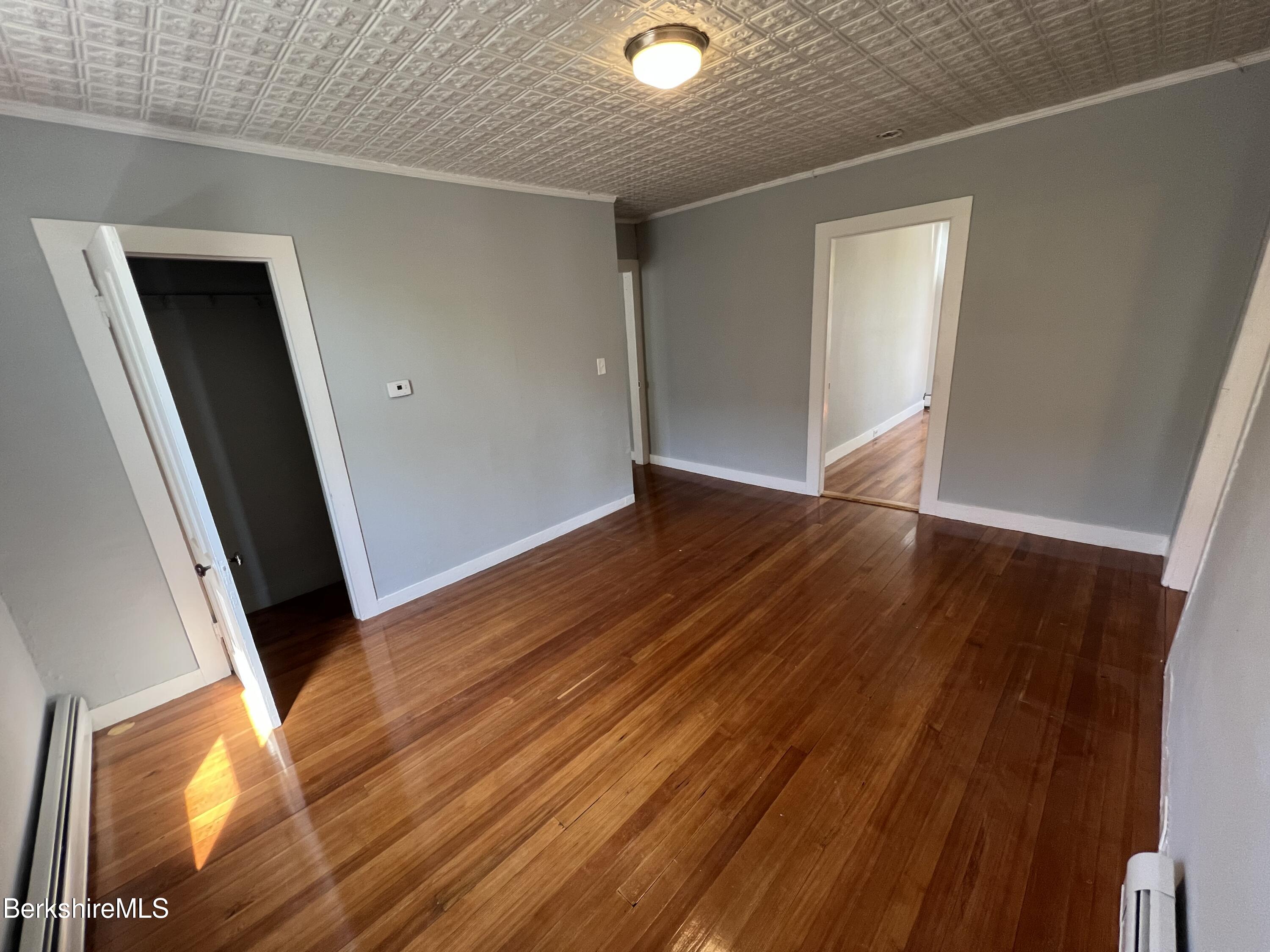 71 Howard Street Pittsfield, MA 01201 - Photo 28 of 42 an empty room with wooden floor and windows