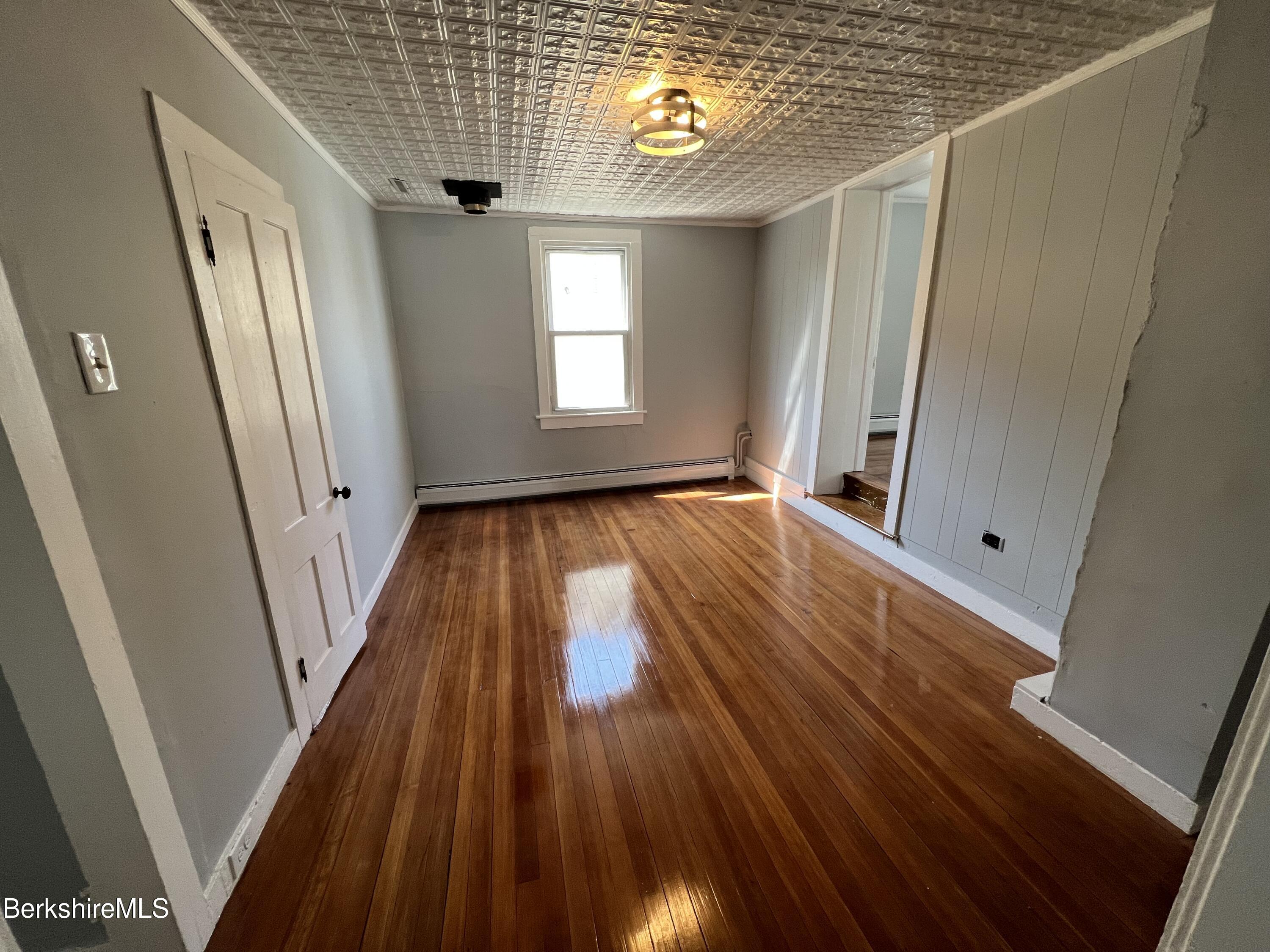 71 Howard Street Pittsfield, MA 01201 - Photo 29 of 42 a view of a hallway with wooden floor and staircase
