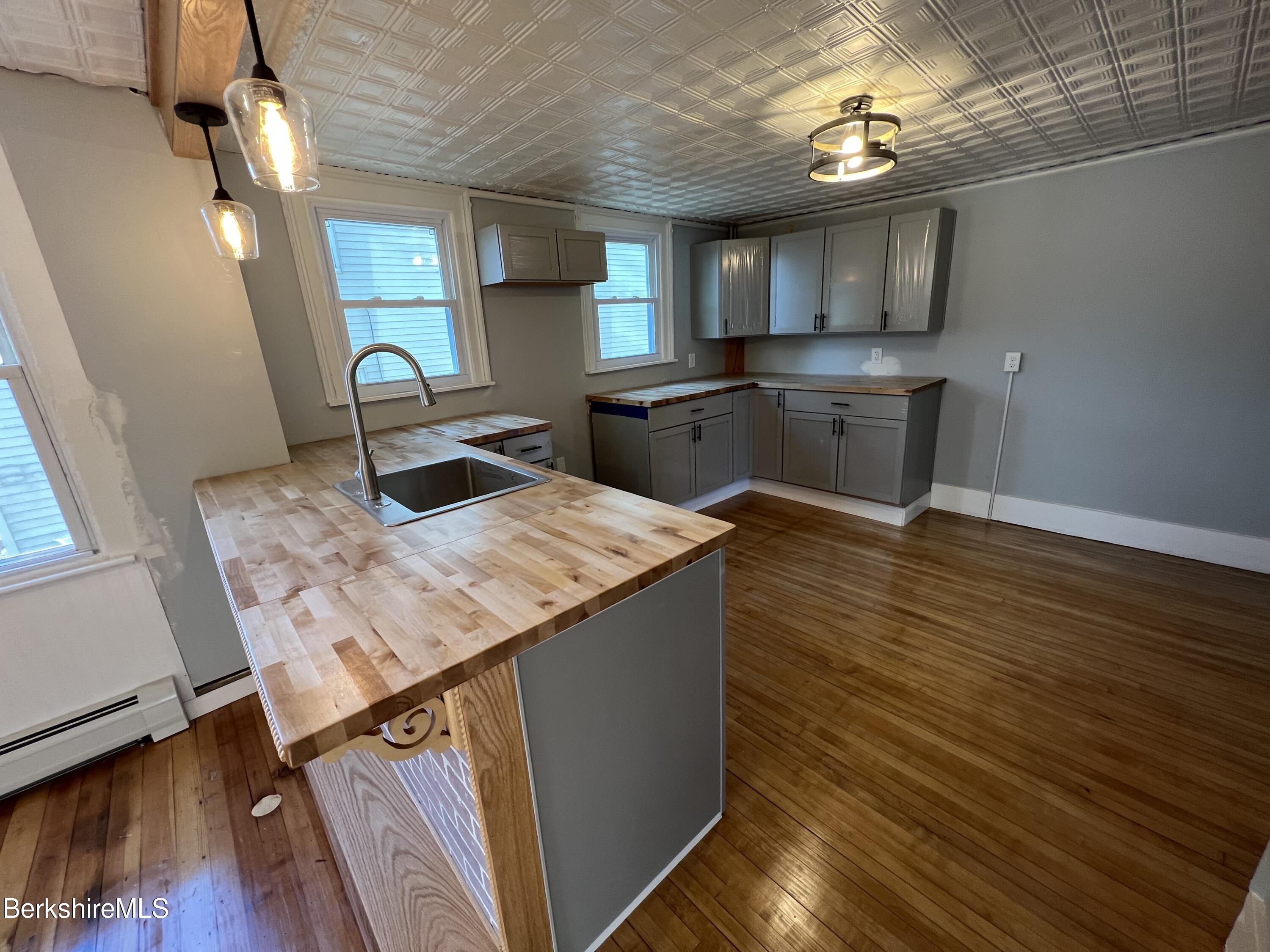 71 Howard Street Pittsfield, MA 01201 - Photo 10 of 42 a kitchen with a sink dishwasher a stove and a wooden floor