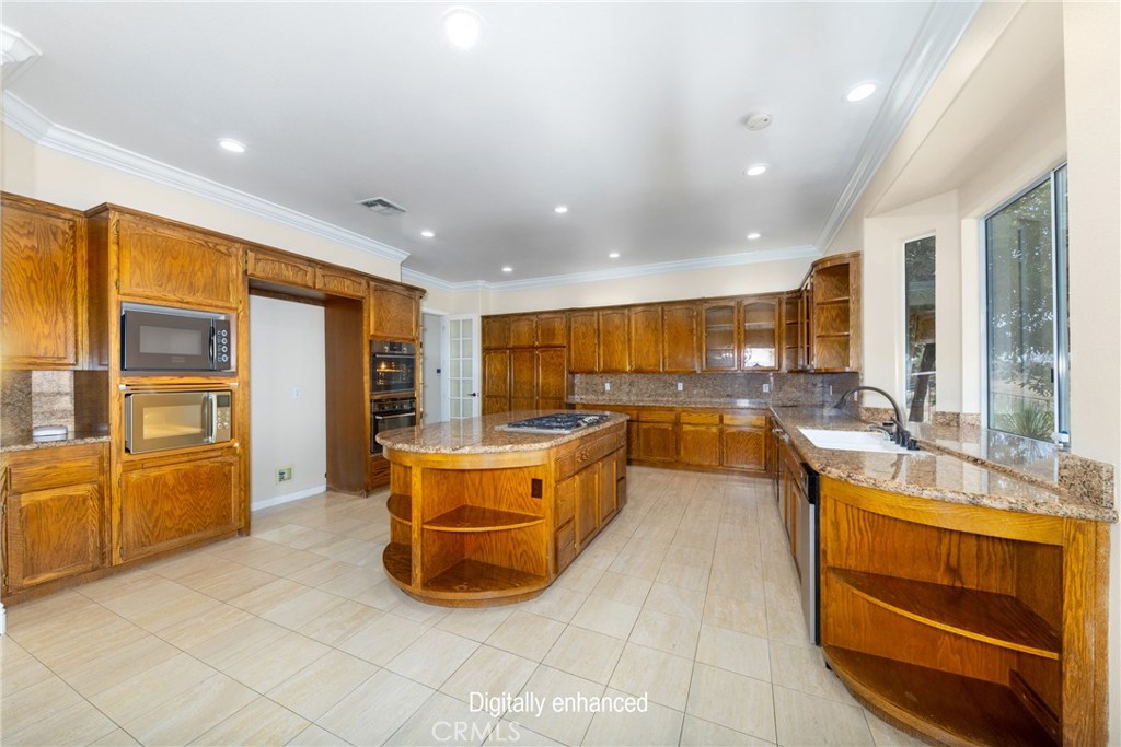 7007 Golden Vale Drive Riverside, CA 92506 - Photo 39 of 72 a large kitchen with stainless steel appliances granite countertop a large window and a counter top space