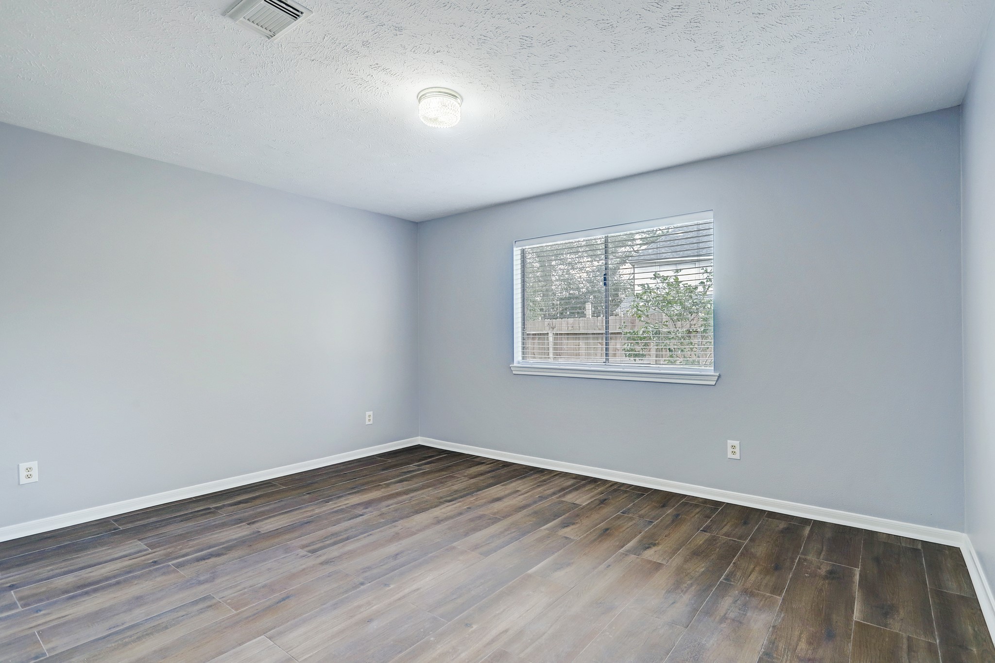 7403 Manor Bridge Court Houston, TX 77095 - Photo 8 of 11 wooden floor in an empty room with a window