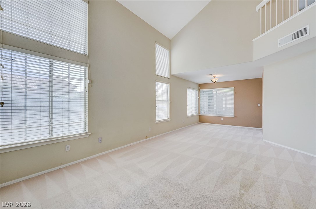 9301 Magic Flower Avenue Las Vegas, NV 89134 - Photo 10 of 70 This expansive living area boasts vaulted ceilings and abundant natural light, offering an inviting atmosphere for daily living.