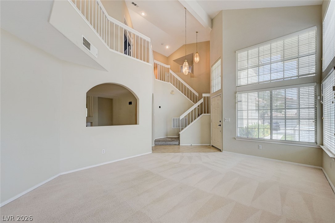 9301 Magic Flower Avenue Las Vegas, NV 89134 - Photo 11 of 70 This living area features a grand two-story entry with an open staircase and abundant natural light.