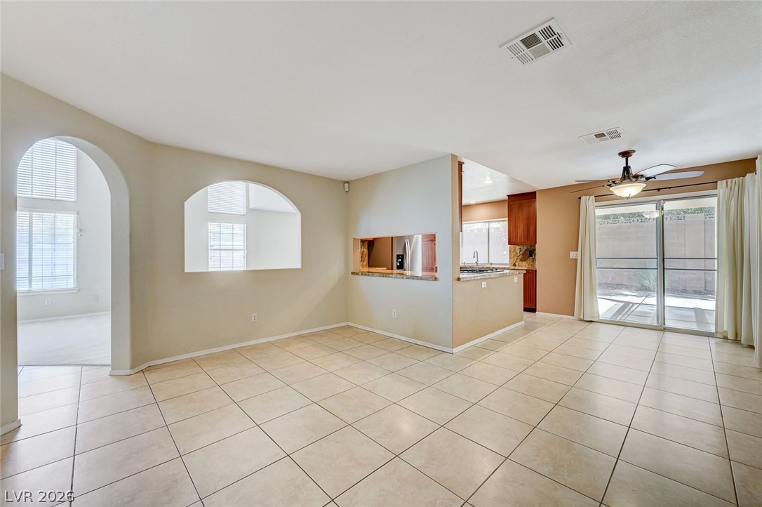 9301 Magic Flower Avenue Las Vegas, NV 89134 - Photo 17 of 70 This bright and open living area features arched doorways, tile flooring, and a sliding glass door.