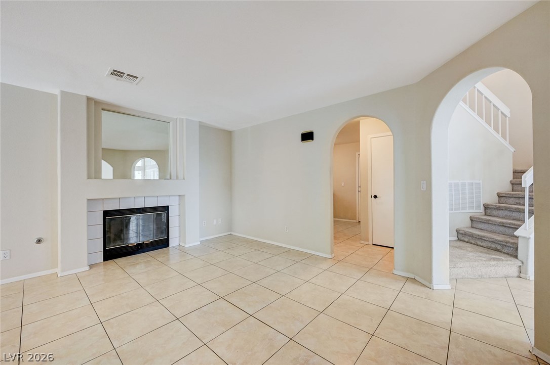 9301 Magic Flower Avenue Las Vegas, NV 89134 - Photo 19 of 70 This bright living area features a fireplace and staircase, ideal for gatherings.