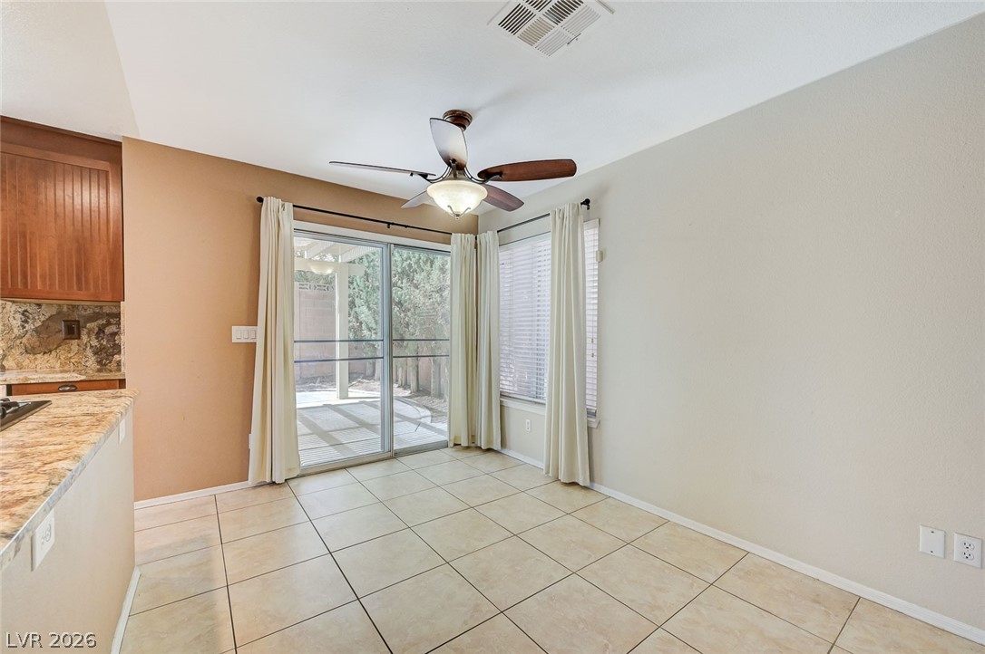 9301 Magic Flower Avenue Las Vegas, NV 89134 - Photo 22 of 70 Bright dining area with tile flooring and backyard access through sliding glass doors.