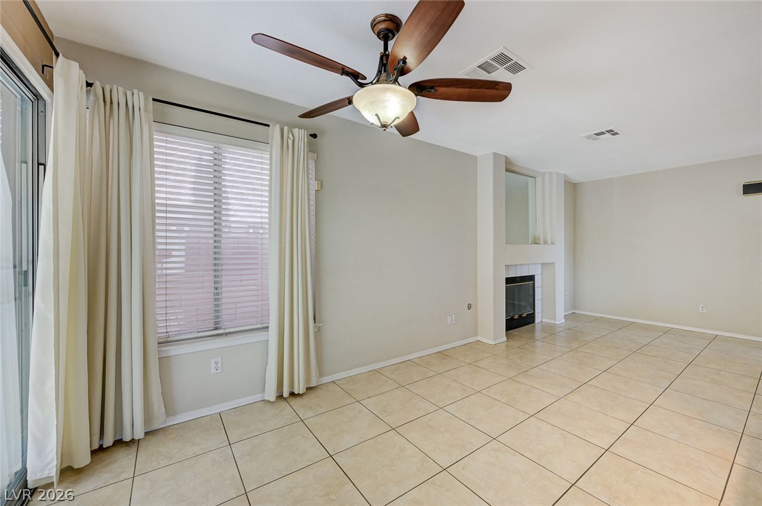 9301 Magic Flower Avenue Las Vegas, NV 89134 - Photo 26 of 70 This bright living space features a fireplace and tiled flooring, offering a comfortable and inviting atmosphere.