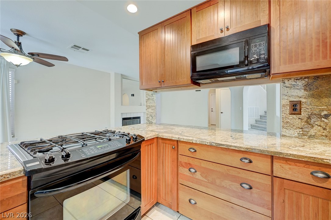9301 Magic Flower Avenue Las Vegas, NV 89134 - Photo 31 of 70 This kitchen boasts warm cabinetry, ample counter space, and modern appliances.