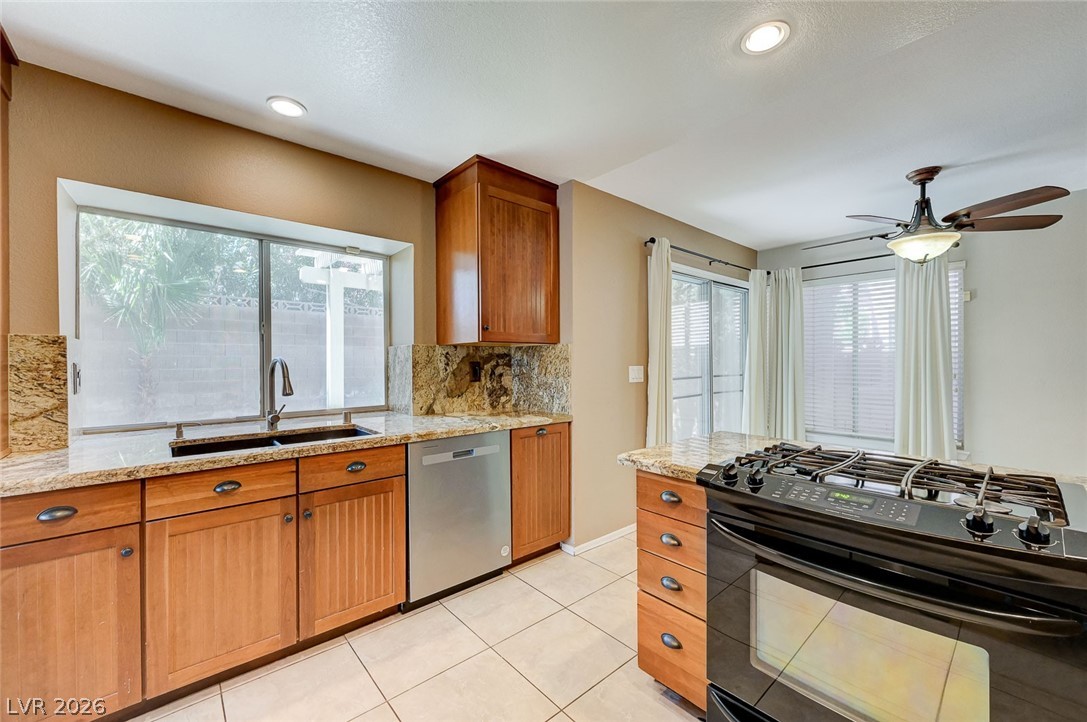 9301 Magic Flower Avenue Las Vegas, NV 89134 - Photo 34 of 70 This functional kitchen features ample counter space, modern appliances, and a view of the outdoor patio.
