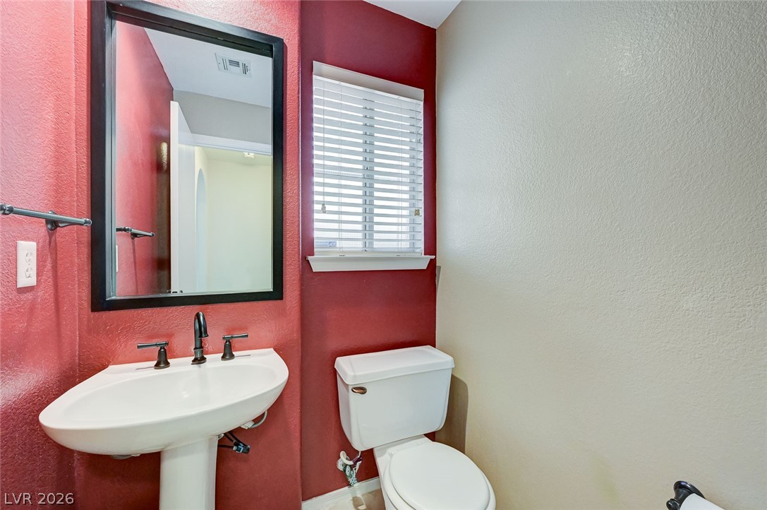 9301 Magic Flower Avenue Las Vegas, NV 89134 - Photo 35 of 70 This functional powder room features a pedestal sink and toilet, perfect for guests.