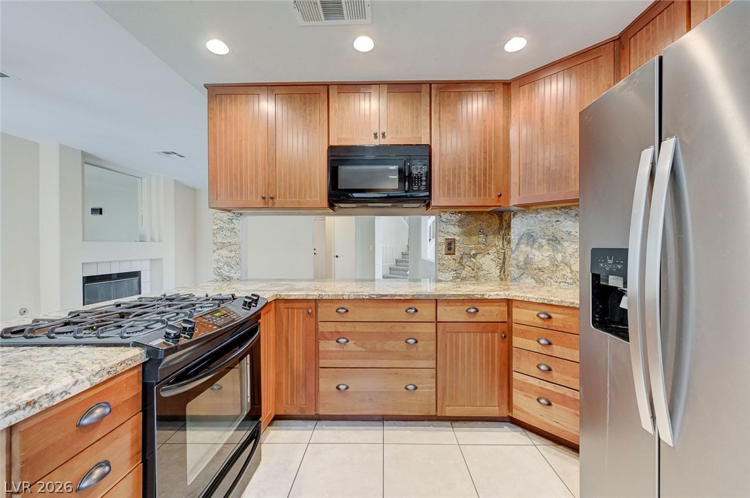 9301 Magic Flower Avenue Las Vegas, NV 89134 - Photo 3 of 70 This functional kitchen features ample cabinetry, granite counters, and modern appliances for daily living.
