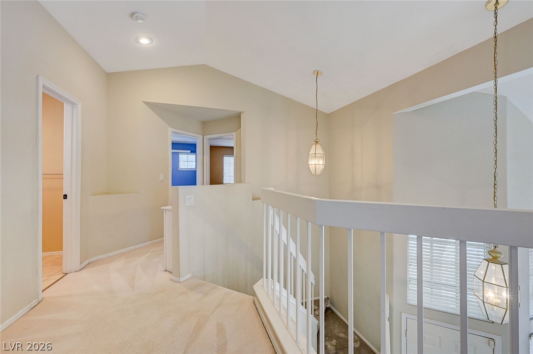 9301 Magic Flower Avenue Las Vegas, NV 89134 - Photo 38 of 70 This bright hallway showcases high ceilings, inviting recessed lighting, and soft carpet flooring.