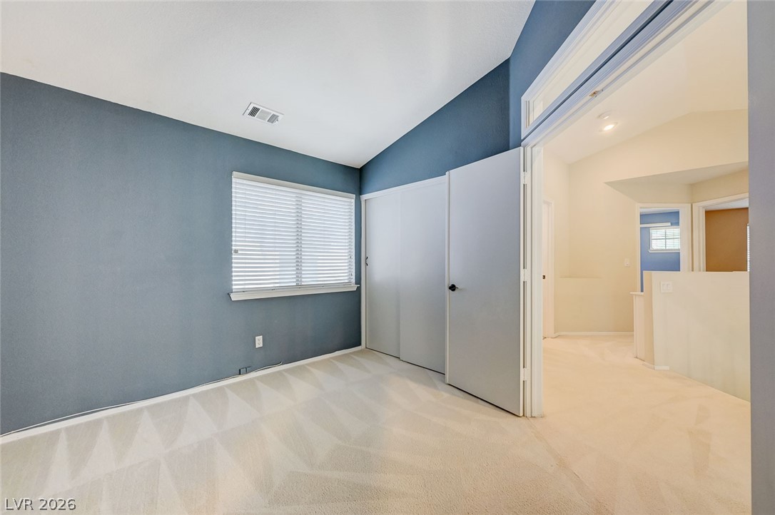 9301 Magic Flower Avenue Las Vegas, NV 89134 - Photo 39 of 70 This spacious bedroom offers comfortable carpeting and a bright window, creating a serene personal retreat.