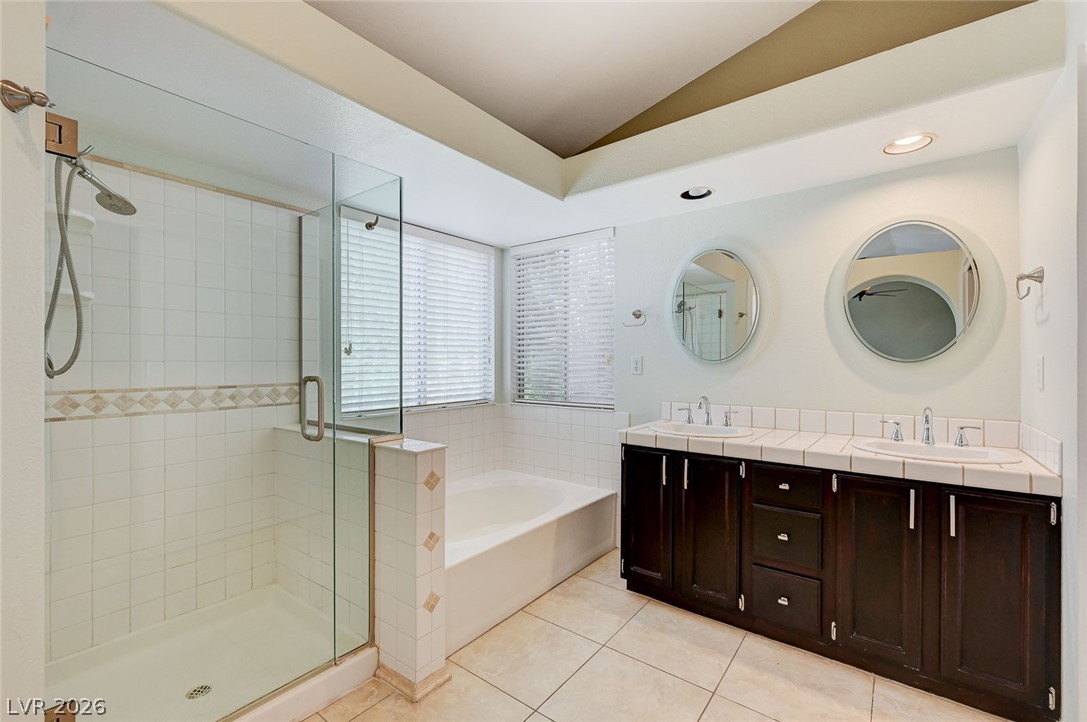 9301 Magic Flower Avenue Las Vegas, NV 89134 - Photo 48 of 70 This spacious bathroom offers dual vanities, a large soaking tub, and a separate glass-enclosed shower.