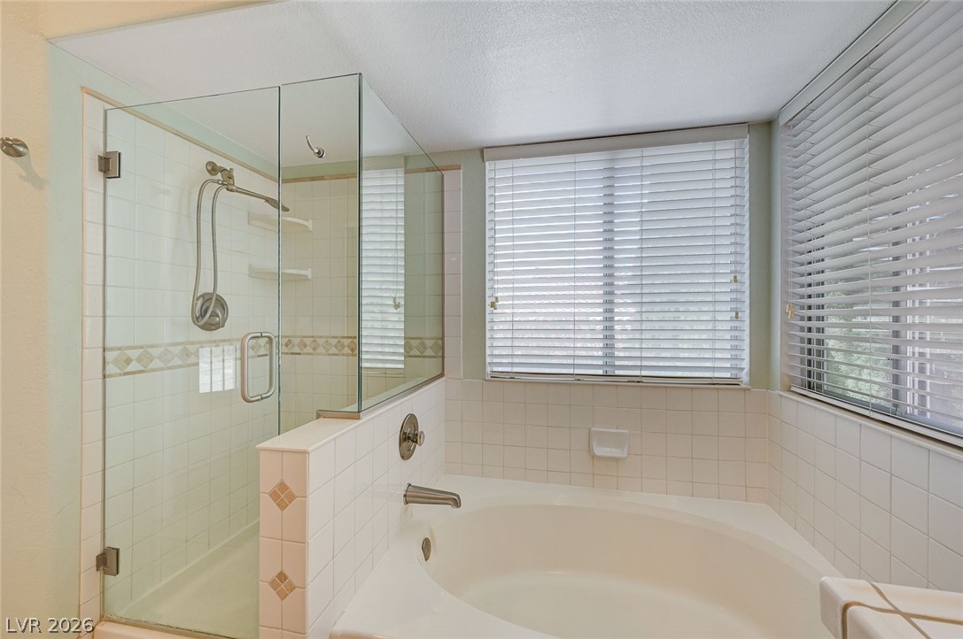 9301 Magic Flower Avenue Las Vegas, NV 89134 - Photo 49 of 70 This bathroom offers a large soaking tub and a spacious shower with sleek glass enclosure.