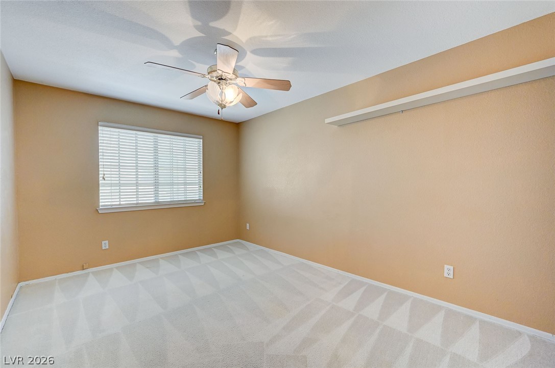 9301 Magic Flower Avenue Las Vegas, NV 89134 - Photo 51 of 70 This airy bedroom offers a comfortable retreat with soft carpet and natural light from the window.