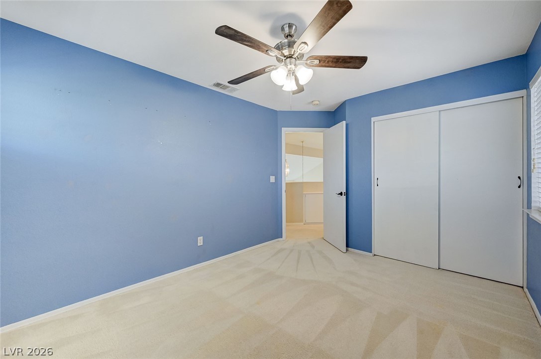 9301 Magic Flower Avenue Las Vegas, NV 89134 - Photo 57 of 70 This inviting bedroom features soft carpeting, a ceiling fan, and ample closet space, ready for personalization.