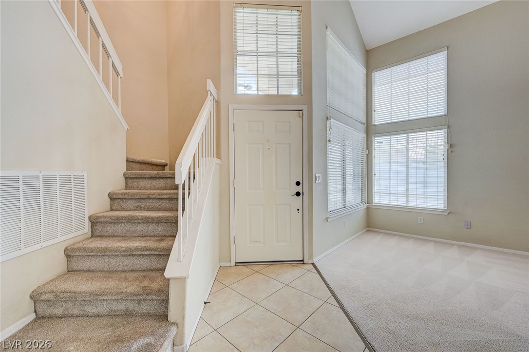 9301 Magic Flower Avenue Las Vegas, NV 89134 - Photo 7 of 70 This bright entry features high ceilings, a welcoming doorway, and a graceful staircase leading to the upper level.