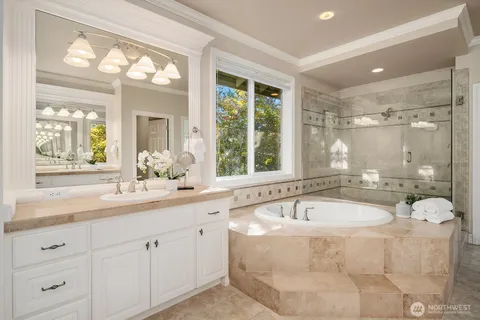 a bathroom with a tub a sink and mirror