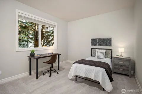 a bedroom with a bed a table and a window