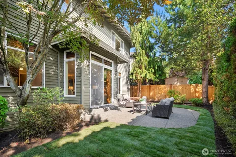 a view of backyard of house with outdoor seating and green space