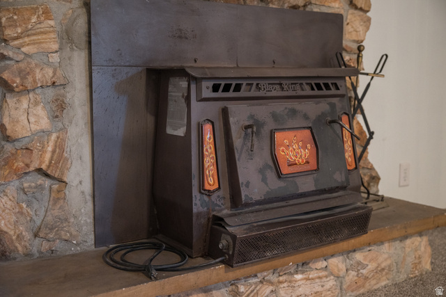 634 South 2100th Street West Vernal, UT 84078 - Photo 34 of 71 Stone fireplace surround featuring a built-in wood-burning stove with decorative detailing