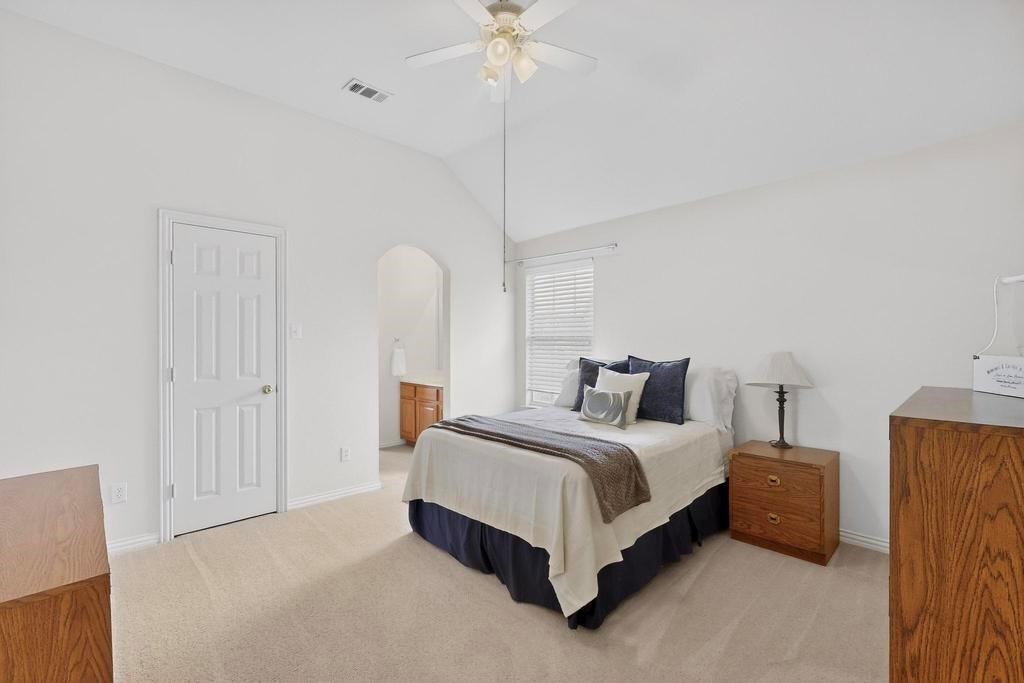 236 Hope Circle Murphy, TX 75094 - Photo 25 of 37 Bedroom with vaulted ceiling, Jack and Jill bathroom, ceiling fan, and arched walkways