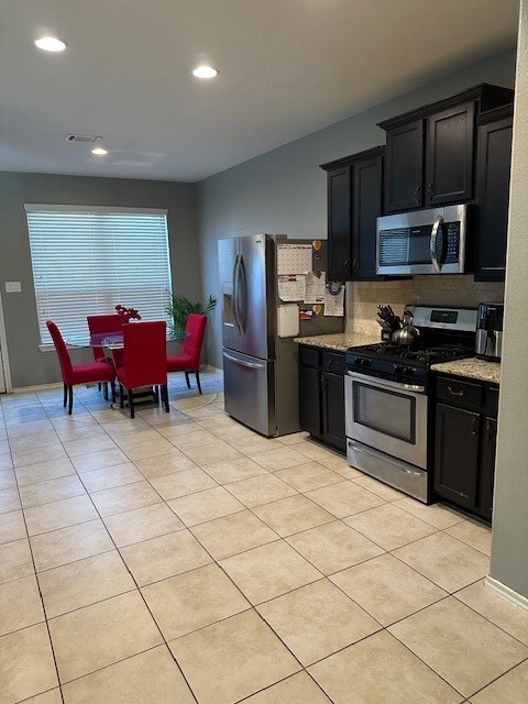 3327 Atherton Ridge Lane Houston, TX 77047 - Photo 4 of 12 a kitchen with stainless steel appliances kitchen island granite countertop a sink dishwasher stove top oven and cabinets