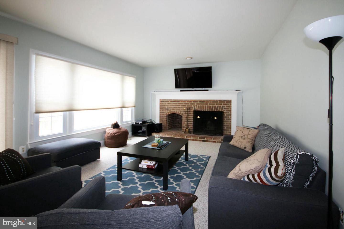 4708 Silverbrook Way Bowie, MD 20720 - Photo 3 of 21 a living room with furniture a fireplace and a flat screen tv