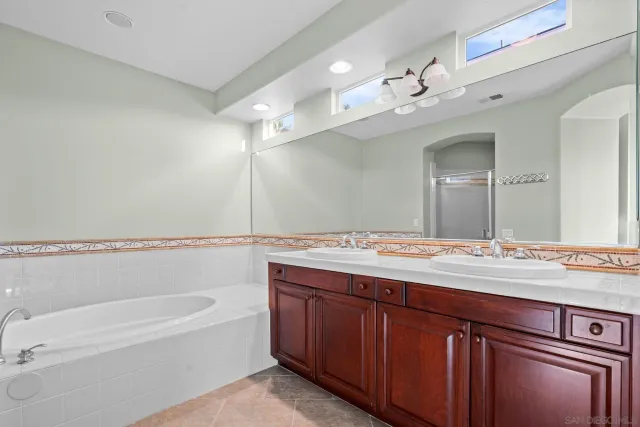 a bathroom with a sink a large mirror and a bathtub