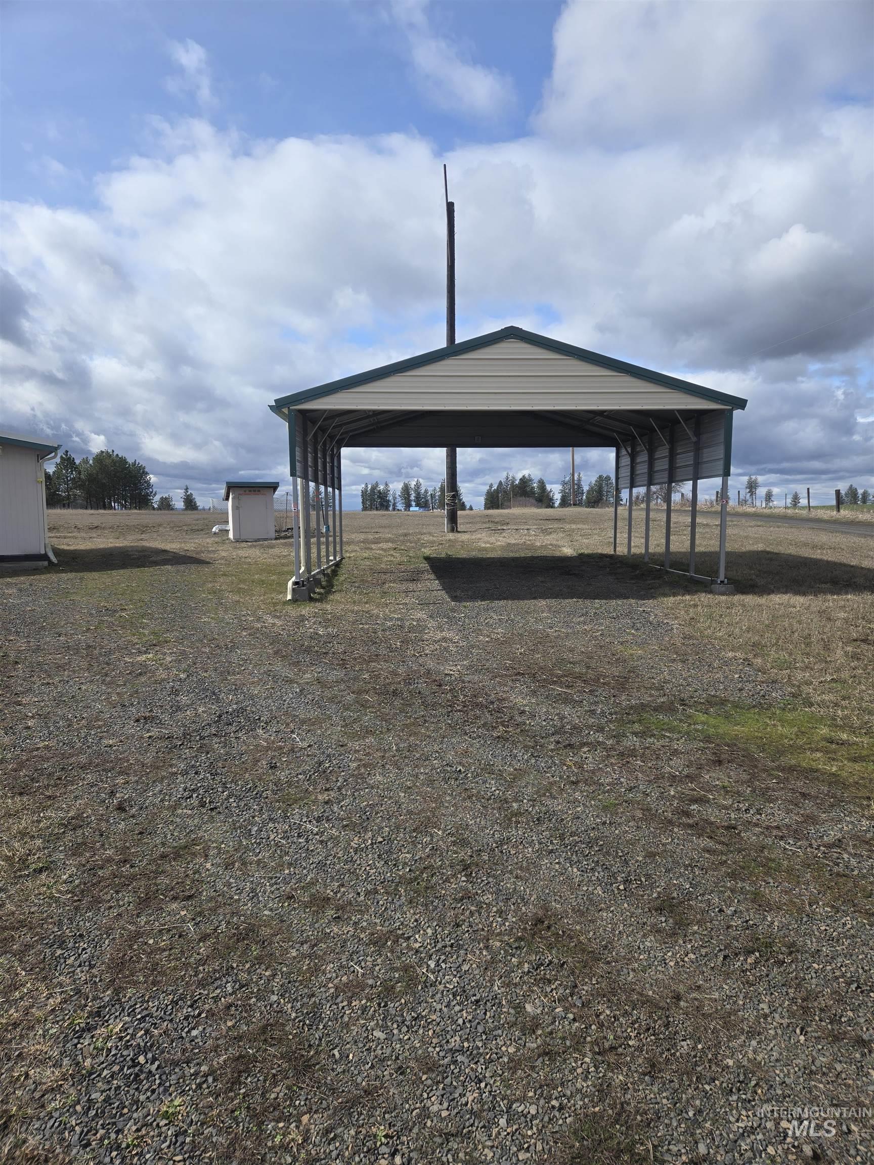 135 Harrisburg Road Kamiah, ID 83536 - Photo 24 of 41 View of yard with a detached carport, driveway, and an outdoor structure