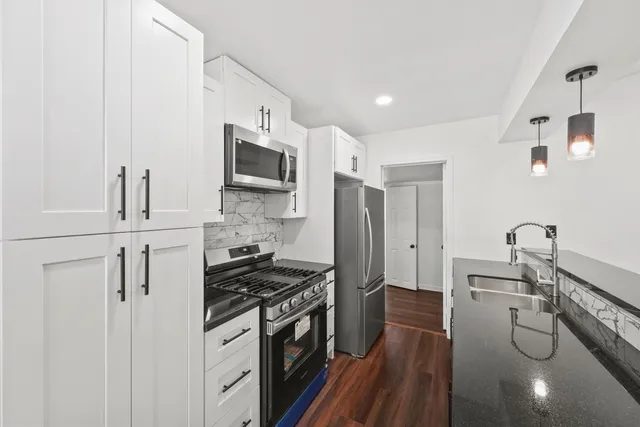 a kitchen with stainless steel appliances a stove a sink a refrigerator and cabinets