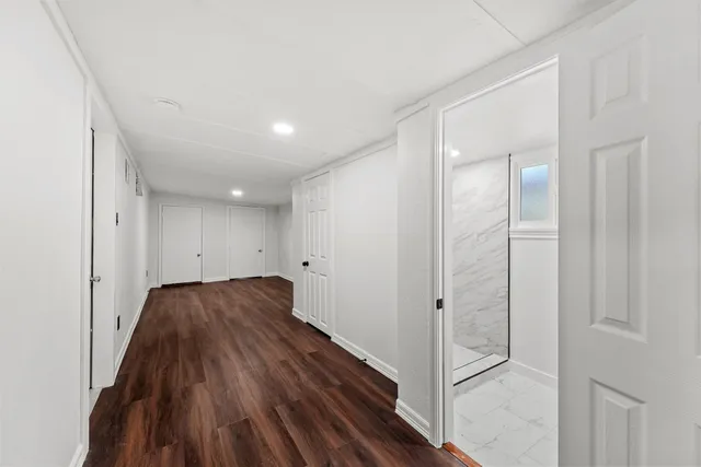 a view of a hallway with wooden floor and staircase