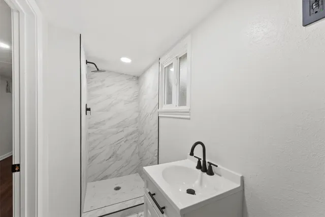 a bathroom with a shower sink and mirror