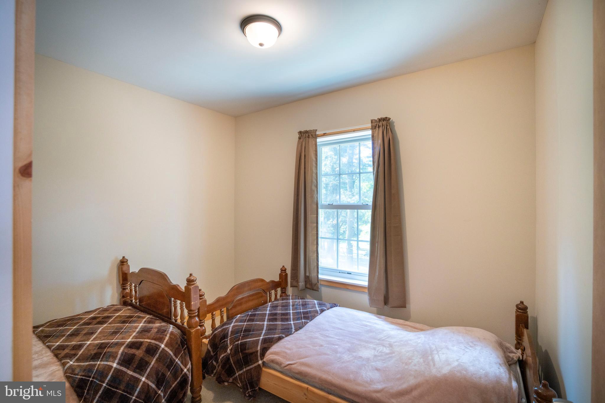 385 Elk Creek Road Aaronsburg, PA 16820 - Photo 52 of 71 a bedroom with two beds and a window