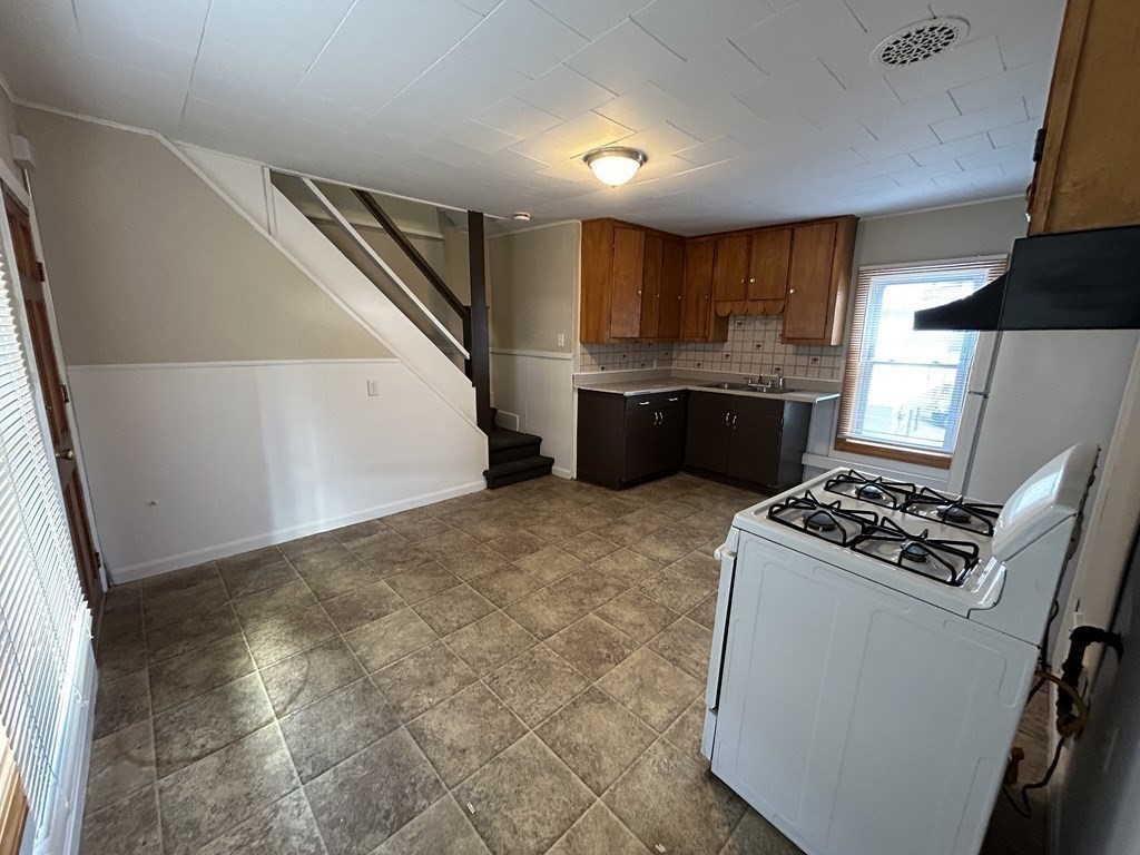 694 Lakeview Avenue, Unit 3 Lowell, MA 01850 - Photo 4 of 19 a kitchen with a stove and a refrigerator