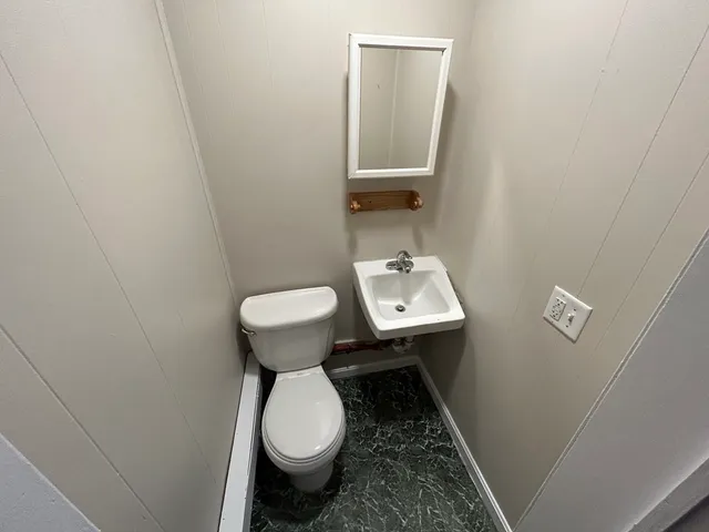 a bathroom with a sink toilet and a mirror