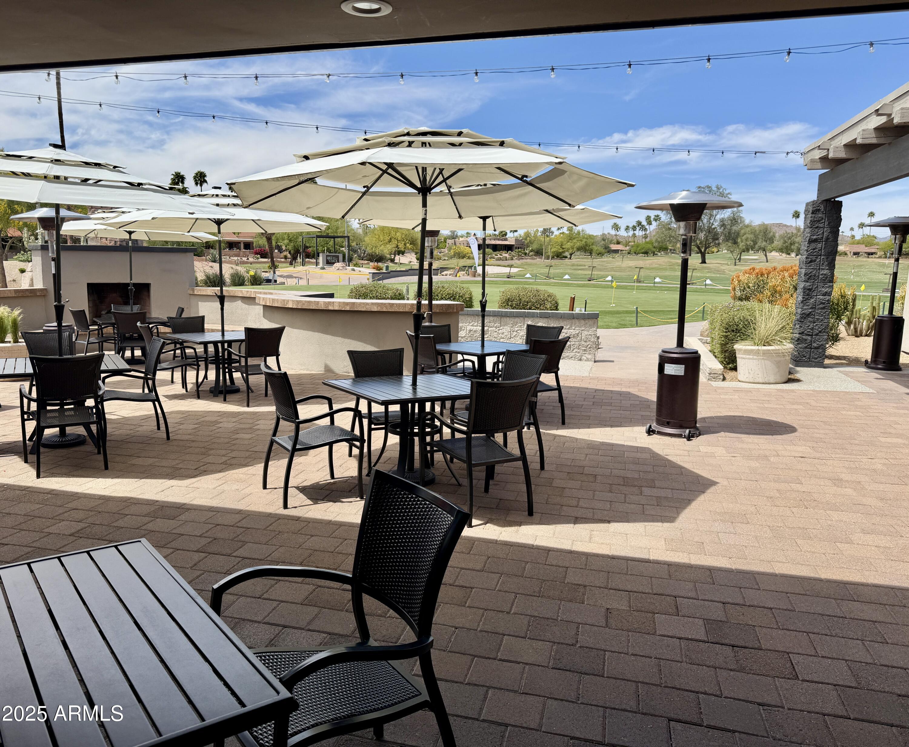 25615 North Bolero Bend, Unit 5 Rio Verde, AZ 85263 - Photo 34 of 65 a view of a patio with a dining table and chairs under an umbrella