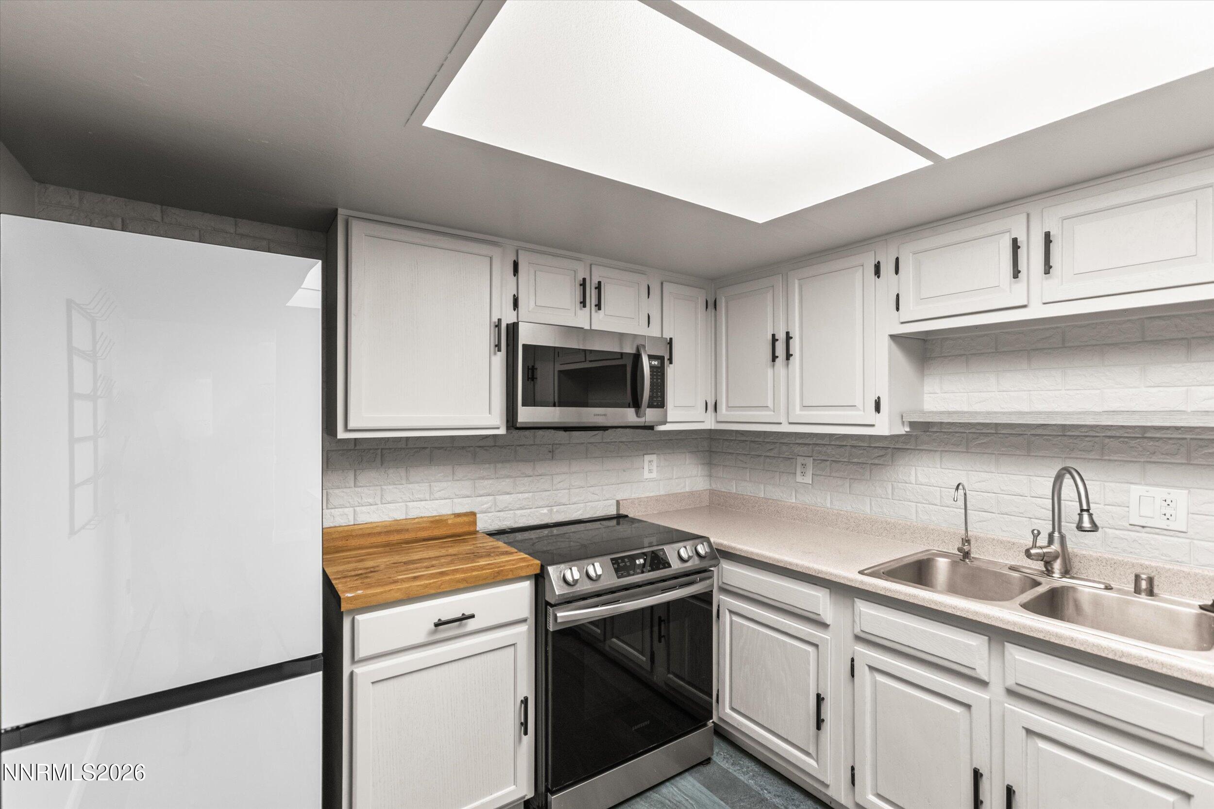 2300 Dickerson Road, Unit 51 Reno, NV 89503 - Photo 9 of 46 a kitchen with stainless steel appliances granite countertop white cabinets a sink and dishwasher