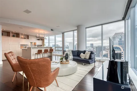 a kitchen with stainless steel appliances a dining table chairs and wooden floor