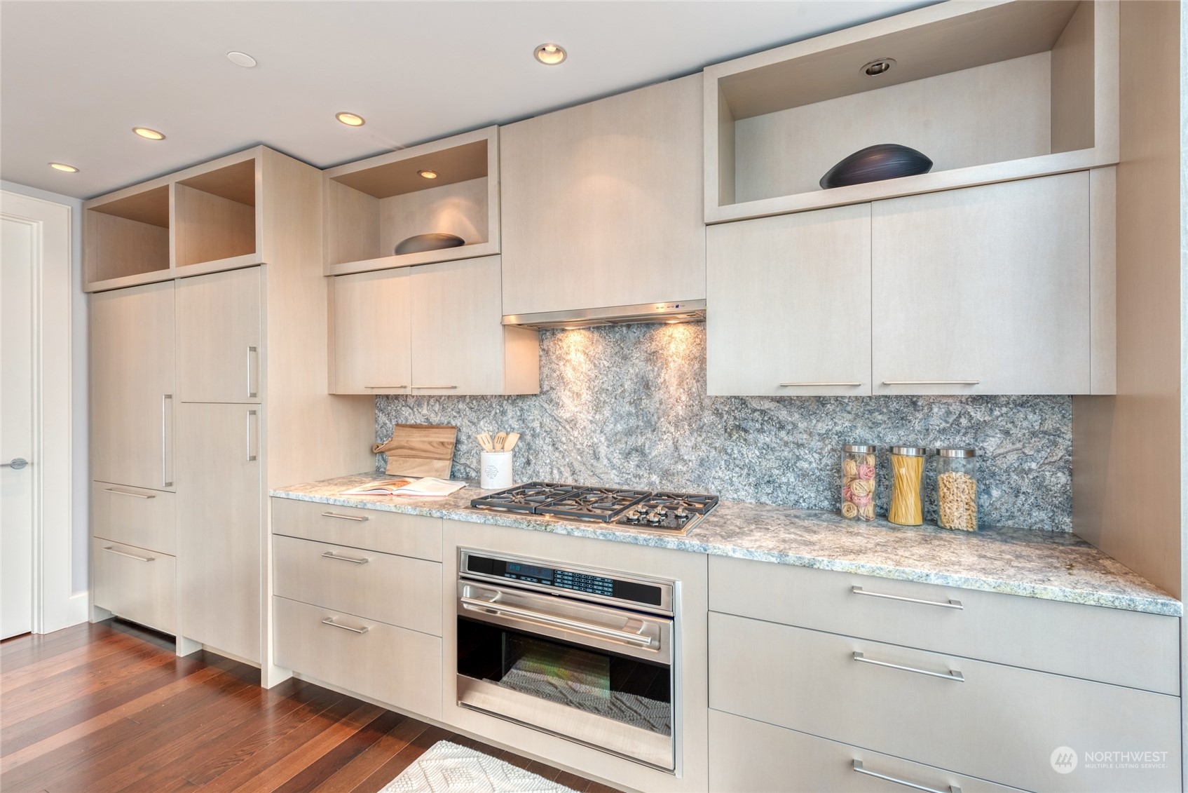 1521 2nd Avenue, Unit 3601 Seattle, WA 98101 - Photo 14 of 39 a kitchen with a stove cabinets and wooden floor