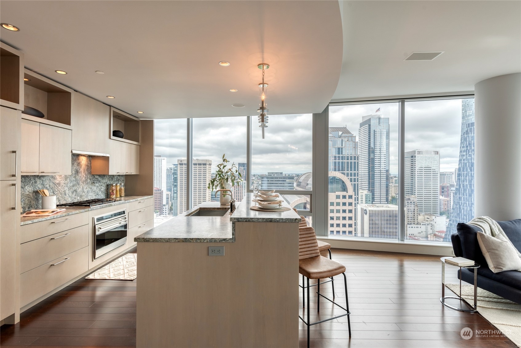 1521 2nd Avenue, Unit 3601 Seattle, WA 98101 - Photo 17 of 39 a large kitchen with kitchen island a large window cabinets a sink and stainless steel appliances