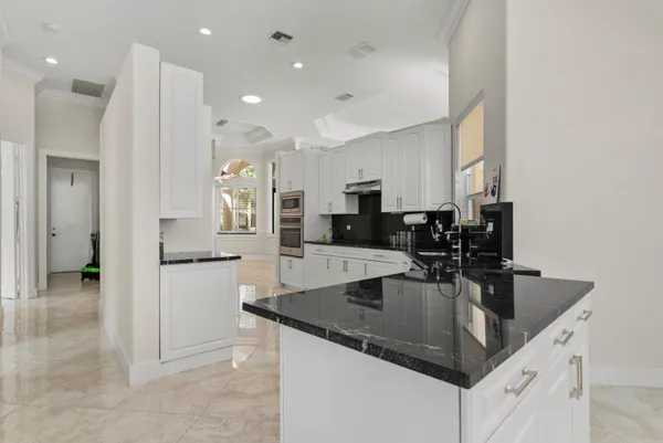 a kitchen with a center island a sink stainless steel appliances and cabinets